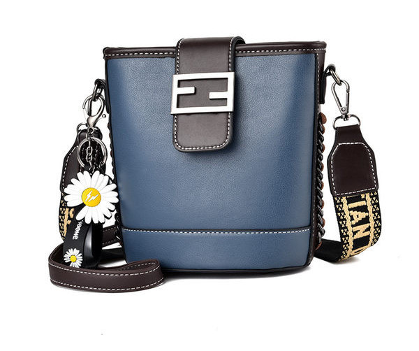 Moderna ženska torba s metalnim kopčanjem i izvezenim natpisom na remenu