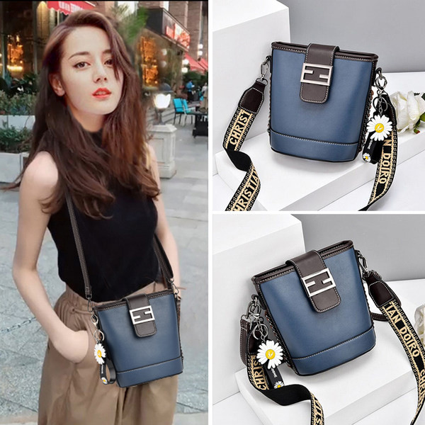 Moderna ženska torba s metalnim kopčanjem i izvezenim natpisom na remenu