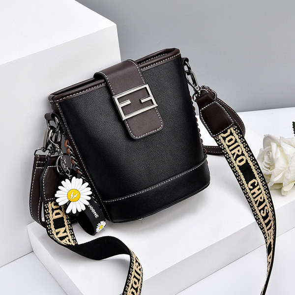 Moderna ženska torba s metalnim kopčanjem i izvezenim natpisom na remenu