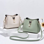 Mala ženska torba sa metalnim ukrasom i duga torba