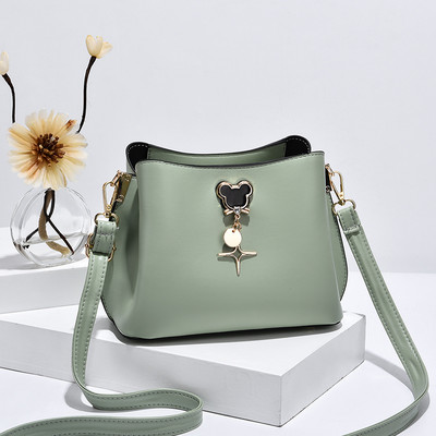 Mala ženska torba sa metalnim ukrasom i duga torba