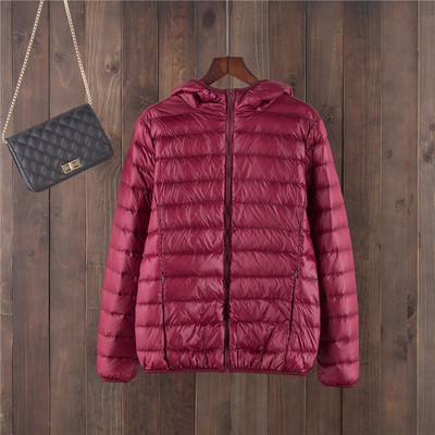 Egyszínű női kabát kapucnival és cipzárral