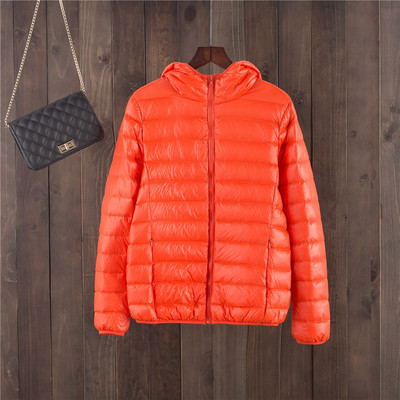 Egyszínű női kabát kapucnival és cipzárral