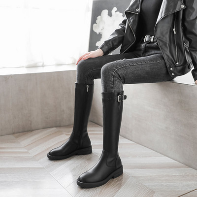 Modern women`s boots made of eco leather with a buckle